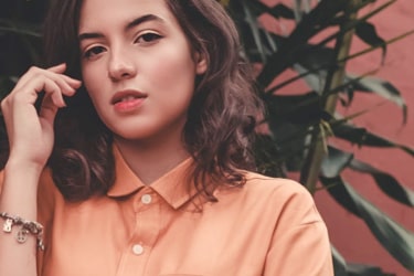 women wearing an orange color shirt looking at the camera